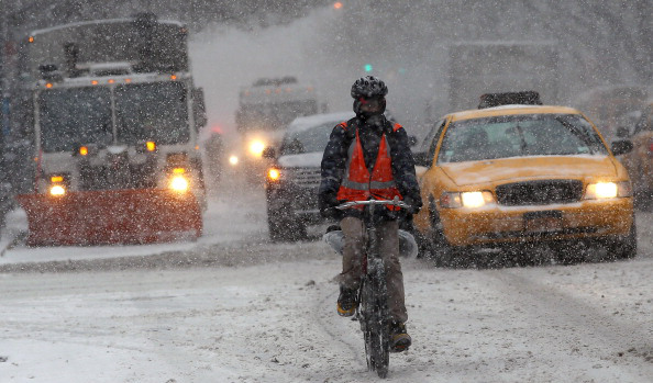 NEW YORK, NY - JANUARY 21:  A man rides a bicycle in Manhattan during a snowstorm that is moving through the Northeast on January 21, 2014 in New York City. Along with dropping arctic tempertures the storm is expected to bring three to five inches by nightfall, with another four to six inches falling overnight.  (Photo by Spencer Platt/Getty Images)